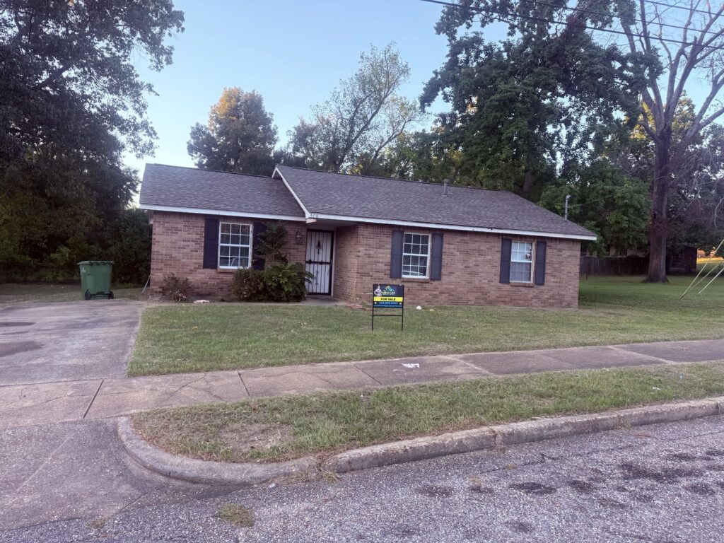 Brick home exterior with New Life Realty for-sale sign