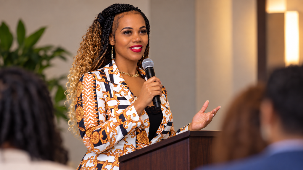 Tesha Perry speaking with a microphone to a workshop audience